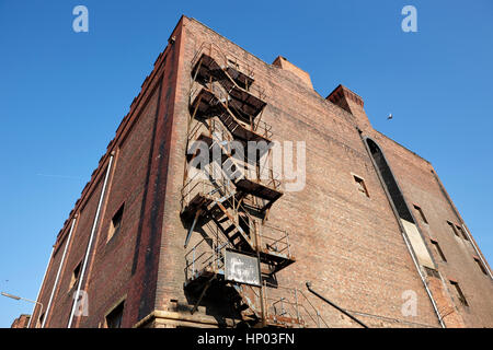 alte Metall Feuerleiter auf rotem Backstein Lagerhalle Liverpool docks uk Stockfoto