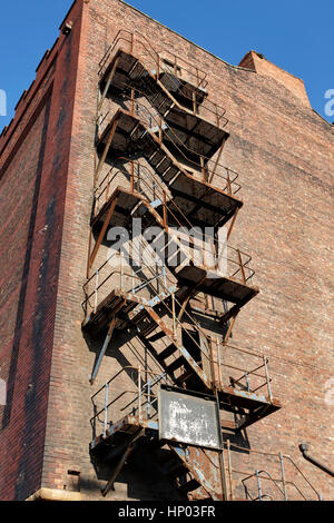 alte Metall Feuerleiter auf rotem Backstein Lagerhalle Liverpool docks uk Stockfoto