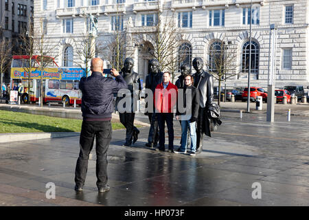 Touristen fotografieren mit der Beatles-Statue vor Pier head Wahrzeichen Gebäude Liverpool uk Stockfoto