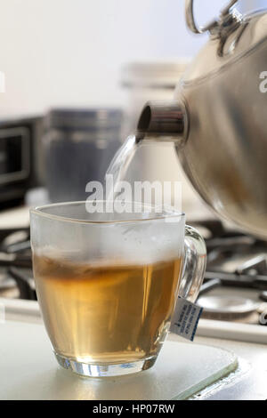 Abfolge des Gießens von Wasser in einen Glaskrug, während Sie heißen Tee brauen Stockfoto