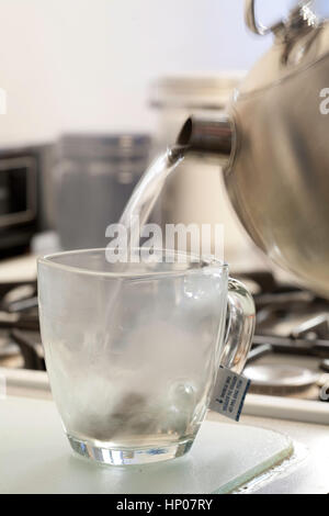 Abfolge des Gießens von Wasser in einen Glaskrug, während Sie heißen Tee brauen Stockfoto