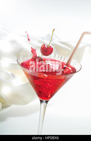 Nahaufnahme Foto des Cerrys fallen in rot cocktail mit Eis Cubs "und" Strawred cocktail Stockfoto