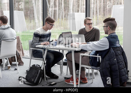 Junge männliche Studenten sitzen und studieren in coworking Space in Vilnius University Library, Litauen Stockfoto