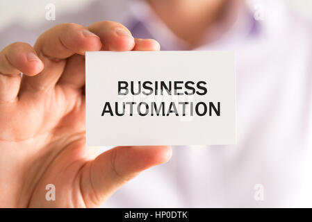 Closeup auf Geschäftsmann hielt eine Karte mit Text BUSINESS AUTOMATION, Firmen-Konzept-Image mit soft-Fokus-Hintergrund Stockfoto