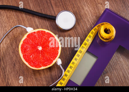 Digitale elektronische Personenwaage für Gewicht des menschlichen Körpers, Maßband und medizinische Stethoskop mit frischer Grapefruit, Konzept des Gesundheitswesens, gesund Stockfoto