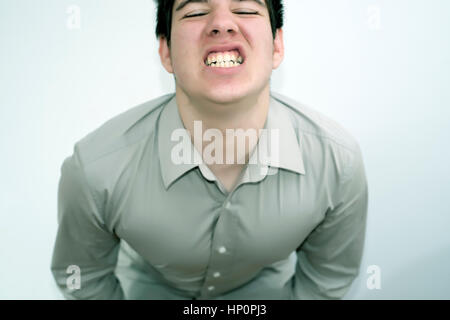 Junger Mann ist seine Zähneknirschen und wütend. Stockfoto