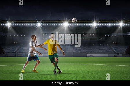 Zwei Fußball-Spieler vom gegnerischen Team auf dem Feld. Mixed-media Stockfoto