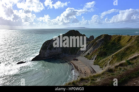 Atemberaubende Landschaft von Dorset. Lulworth, Vereinigtes Königreich. Blauer Himmel mit Wolken, türkisfarbenes Meer, Strand, und felsigen grüne Klippen, schönem Wetter. Marine im Herbst. Stockfoto