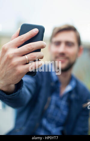 Mann mit Smartphone, ein Selbstporträt zu nehmen Stockfoto