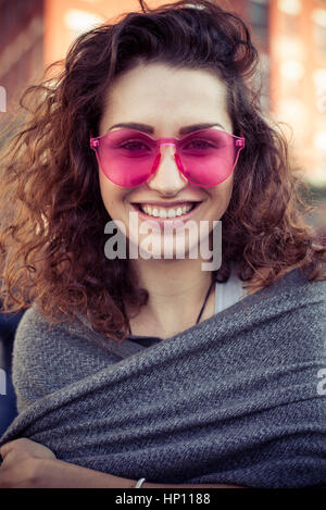 Frau Rosa Sonnenbrille lächelt fröhlich, Porträt Stockfoto