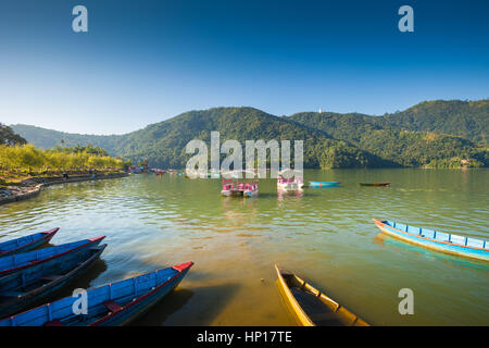 Ruderboote aufgereiht am Fewa Lake (Phewa Tal), Pokhara, Nepal mit Machhapuchre im Hintergrund Stockfoto