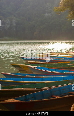 Ruderboote aufgereiht am Fewa Lake (Phewa Tal), Pokhara, Nepal mit Machhapuchre im Hintergrund Stockfoto