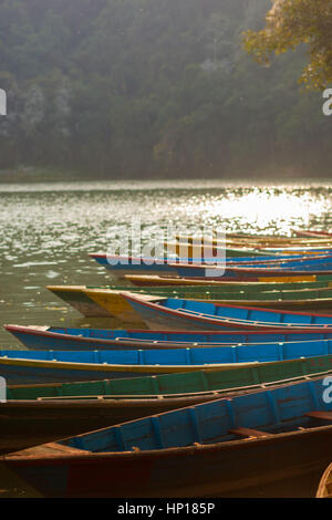 Ruderboote aufgereiht am Fewa Lake (Phewa Tal), Pokhara, Nepal mit Machhapuchre im Hintergrund Stockfoto