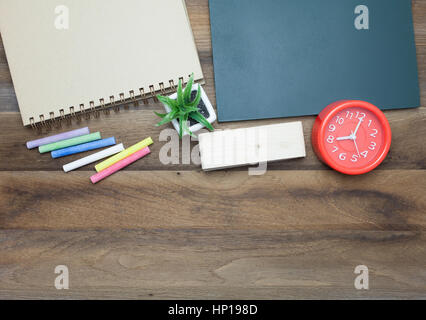 Rote Uhr, bunte Kreiden, Chalk Board, Buch und Radiergummi auf hölzernen Hintergrund Stockfoto