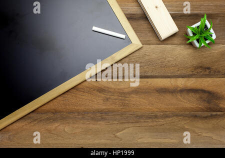 Kreide, Tafel und Radiergummi auf hölzernen Hintergrund Stockfoto