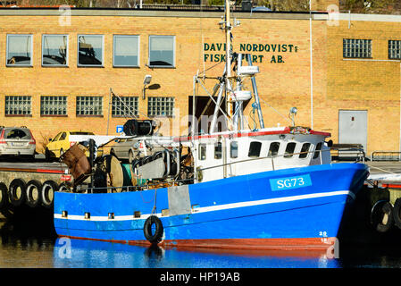 Nogersund, Schweden - 14. Februar 2017: Dokumentation der hellen blauen Fischerboot oder Trawler außerhalb einer Fischerei-Industrie in den Docks. Stockfoto