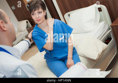 Ein Arzt ist die Prüfung eines Patienten mit Schmerzen in der Schulter im Krankenhaus durchführen. Stockfoto