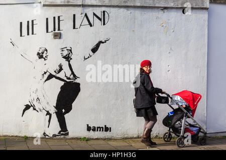 Islington, London, 17. Feb 2017. Passanten eine neue Graffiti von street artist Bambi, die uns Präsident Donald Trump und British PM Theresa kann tanzen in "Lüge Lüge Land", ein Hinweis auf den berühmten Film "La La Land" zeigt. Die Arbeit erschien in dieser Woche auf einer Nebenstraße in Islington. Credit: Imageplotter Nachrichten und Sport/Alamy leben Nachrichten Stockfoto