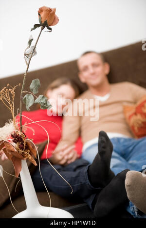 Model Release, Liebespaar Sitzt Gemeinsam Auf der Couch - Liebespaar sitzt auf einer Couch zu Hause Stockfoto