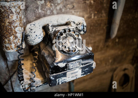 Nahaufnahme eines schmutzigen alten schwarzen Bakelit Telefon mit Lehm in einer Töpferwerkstatt bedeckt Stockfoto