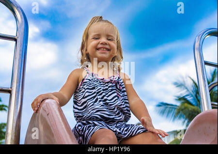 kleines Mädchen gilt für eine Fahrt auf einem Kinder-Hügel. Stockfoto