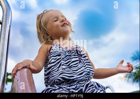 kleines Mädchen gilt für eine Fahrt auf einem Kinder-Hügel. Stockfoto