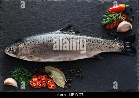 Frische Forellen mit Gewürze und Würzmittel auf ein Schneidebrett Stockfoto