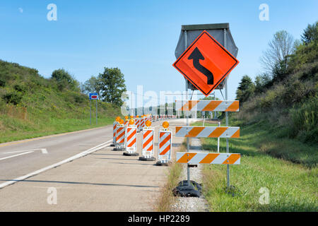 Orange und weiß gestreift reflektierende Leitpfosten Beiträge und Verkehrssteuerung Zeichen Regie Auto Flow zur Verringerung von Unfällen auf der Autobahn im Bau. Stockfoto
