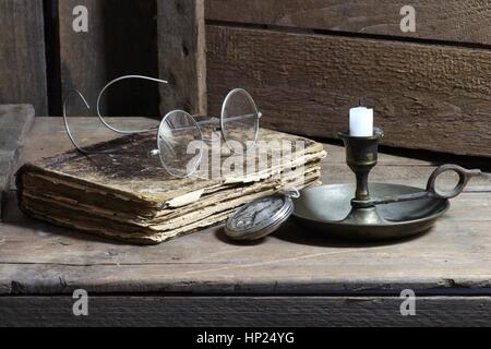 antikes Buch mit Zubehör auf hölzernen Hintergrund Stockfoto