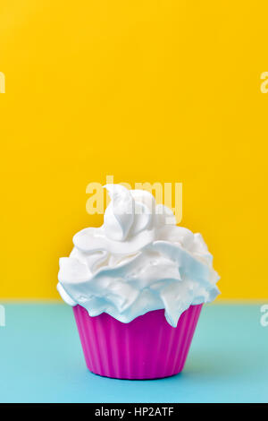 Nahaufnahme von einer weißen Eis auf einem blau-gelben Hintergrund voller rosa Plastikbecher Stockfoto