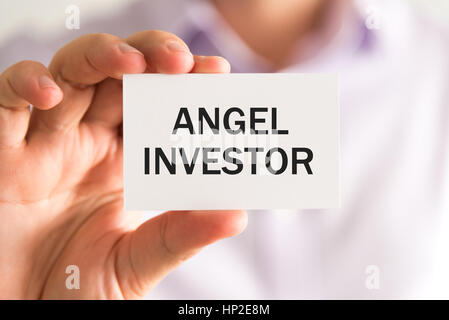 Closeup auf Geschäftsmann hielt eine Karte mit Text ANGEL INVESTOR, Firmen-Konzept-Image mit soft-Fokus-Hintergrund Stockfoto