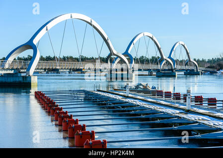 Solvesborg, Schweden - 14. Februar 2017: Ökologische Dokumentarfilm der längsten Fußgängerbrücke in Europa. Die drei Bögen mit Marina und Boot in Stockfoto