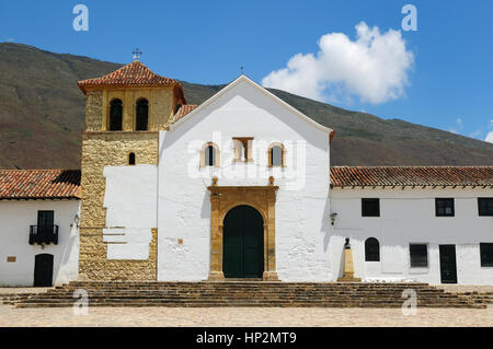 Wunderschöne weiße Villa mit Schindeldächern verborgen hinter Mauern im kolonialen Villa de Leyva. Pfarrkirche auf der Plaza central, Kolumbien, Stockfoto