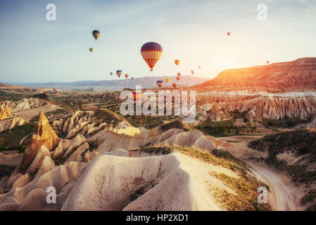 Bunte Heißluftballons fliegen über rote Tal in Cappadocia, Stockfoto