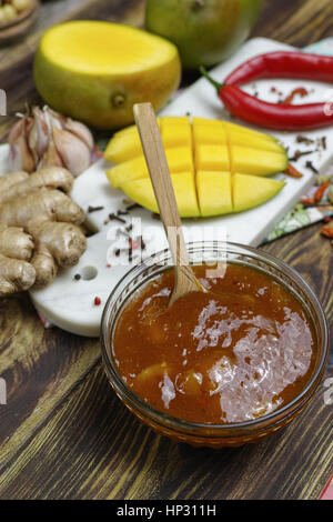 Schüssel mit hausgemachten Frsh Mango-Chutney auf alten Holztisch Stockfoto