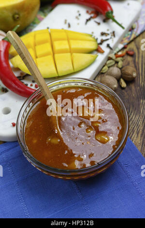 Schüssel mit hausgemachten Frsh Mango-Chutney auf alten Holztisch Stockfoto