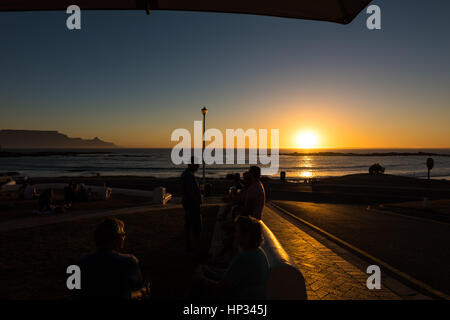 Kapstadt, Südafrika - 15. November 2016: Unbekannte Menschen genießen ihre Getränke während den farbenprächtigen Sonnenuntergang am Strand von Bloubergstrand ich Stockfoto