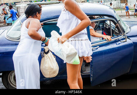 Frauen, die ein Taxi zu bekommen, in Dragones Straße, Centro Habana District, La Habana, Kuba Stockfoto