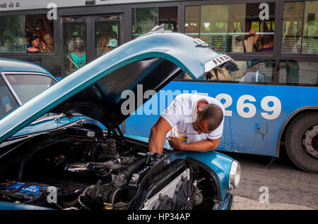 Öffentlicher Bus und Mann Reparatur Autos, Straßenszene in Dragones Straße, Centro Habana District, La Habana, Kuba Stockfoto