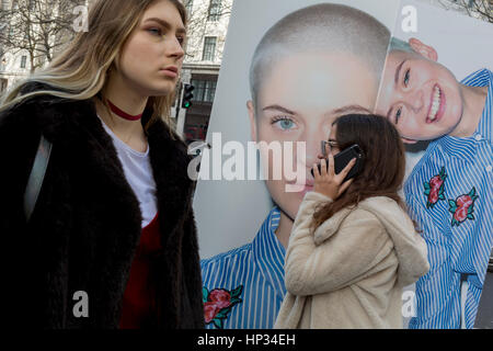 Modelle haben Spaß neben einer Straße Plakatwand für High-Street-Händler New Look, Outisde London Fashion Week in den Strang am 17. Febriary 2017 in London, England, Vereinigtes Königreich. London Fashion Week ist eine Kleidung Messe gehalten in London zweimal jährlich, im Februar und September. Es gehört zu den "Big Four" Fashion Weeks, zusammen mit New York, Mailand und Paris. Der Fashion-Branche spielt eine bedeutende Rolle in der Wirtschaft des Vereinigten Königreichs mit der London Fashion Week allein zu jeder Jahreszeit £ 269 Millionen Scheffeln geschätzt. Die sechs-Tage-Branchen-Event ermöglicht Designer zeigen ihre Kollektionen an Käufer, Journalist Stockfoto