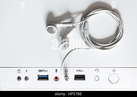 Weiße Kopfhörer verbindet sich mit einer Systemeinheit Stockfoto