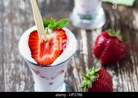 Gefrorene Frucht-Smoothies mit frischen Erdbeeren serviert in gekühlte Gläser hoch oben, Sommer süß behandeln Stockfoto