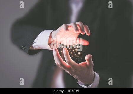 Konzept - Businesssman mit seiner inneren Kraft und Konzentration glühende Teilchen der Energie zwischen seinen Händen Stockfoto
