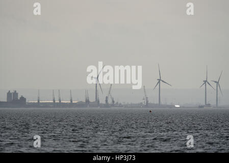 Die Krane von Sheerness Hafen in Kent mit dem Sheerness Windpark hinaus gesehen, von Thorpe Bay in Essex in der Themse-Mündung Stockfoto