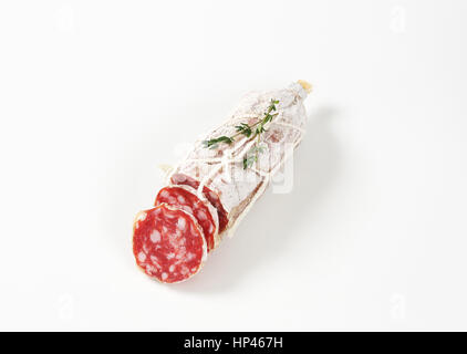 in Scheiben geschnittenen französischen trockene Salami und Thymian auf weißem Hintergrund Stockfoto