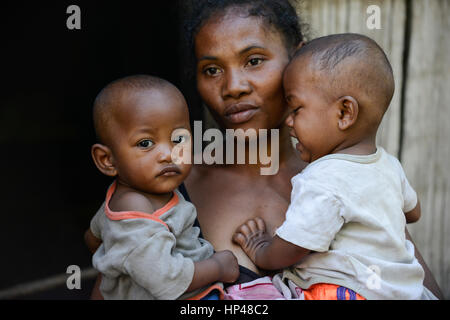 Madagaskar, Mananjary, Stamm ANTAMBAHOAKA, fady, nach den Regeln ihrer Vorfahren Zwillingskinder sind tabu und in der Gesellschaft nicht akzeptiert, diese Mutter ist ihre Zwillingskinder zu akzeptieren, aber sie hat ihr Dorf verlassen und lebt in der Stadt / MADAGASKAR, Recht Sind Ein Fady Oder Tabu Beim Stamm der ANTAMBAHOAKA in der Region Mananjary, Frau CLAUDINE MAROVAVY Mit Ihren Zwillingen JEAN PASCAL NOMENJANAHARY - Rechts-Und MARIE PASCALINE NOMENJANAHARY - Links - , Sie Hut Mit Dachmarke Mann sterben Recht Gegen Das Tabu Behalten Und Ihr Dorf Verlassen Und Lebt Heute in Mananjary Im Stadtviertel A Stockfoto