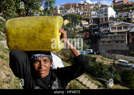 Madagaskar-Antananarivo, Obdachlose Familie, Frau tragen Wasser im Kanister Stockfoto