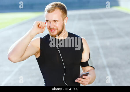 Mann, hören Sie Musik auf Stadion Stockfoto