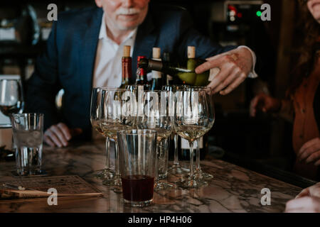 Mann Pourign Gläser Weißwein für Menschen. Stockfoto