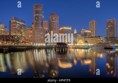 Die Skyline spiegelt sich in den stillen Wassern des Hafens in der letzten Stunde vor Sonnenaufgang, wie ein neuer Tag in Boston, Massachusetts beginnt. Stockfoto
